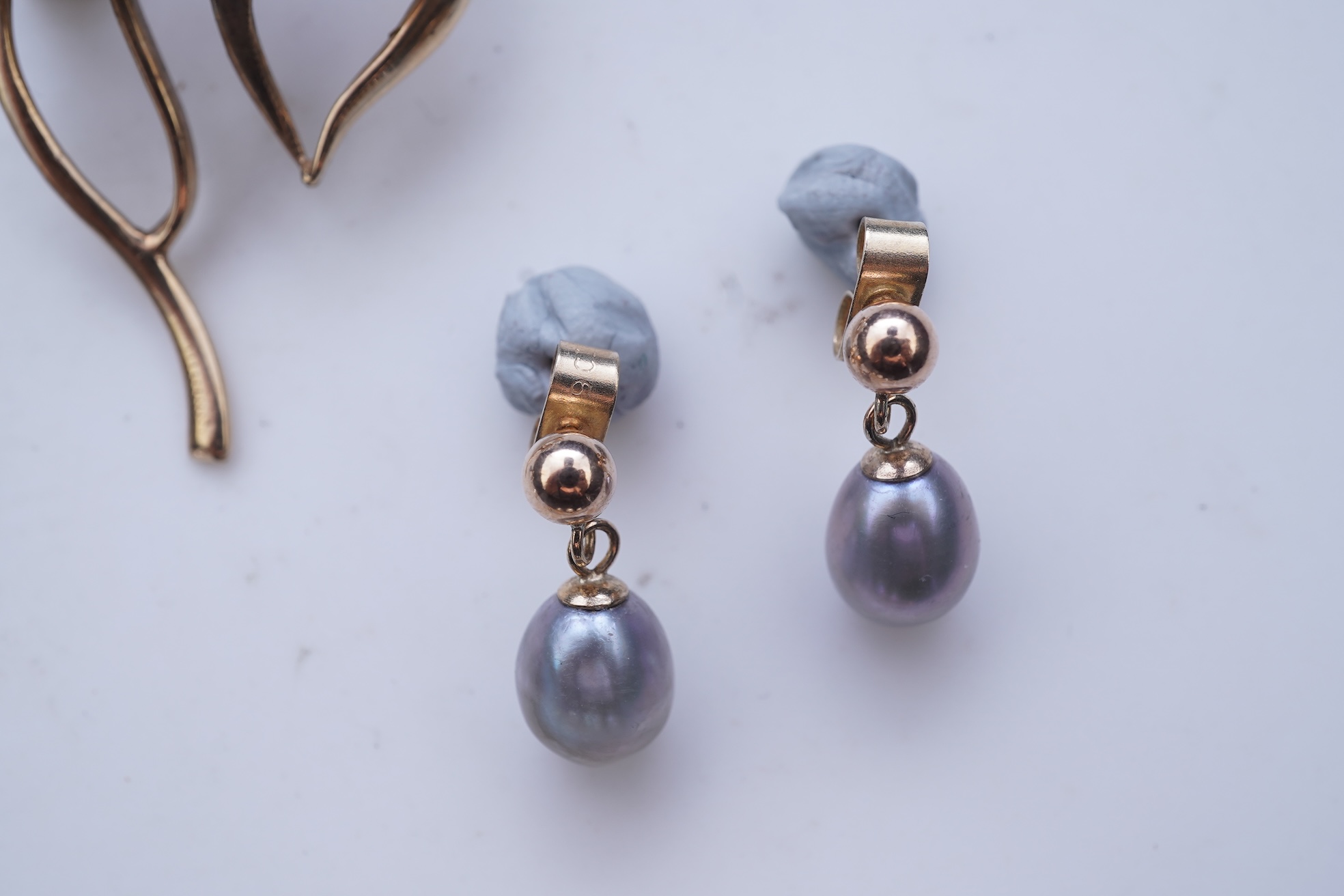 A group of cultured pearl jewels, comprising: two pairs of cultured pearl drop earrings, longest 3cm, mounted in gold; and two cultured pearl brooches mounted in 9ct gold, longest 4.1cm, British hallmarks, combined gross